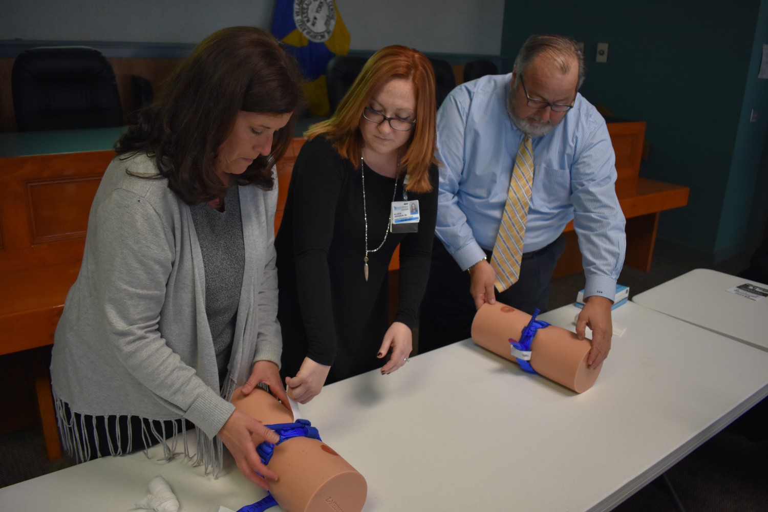 Allison Anderson, center, directed Deputy Mayor Kathy Baxley, left, and Mayor Francis Murray, right, how to stop the bleeding on life-threatening wounds.