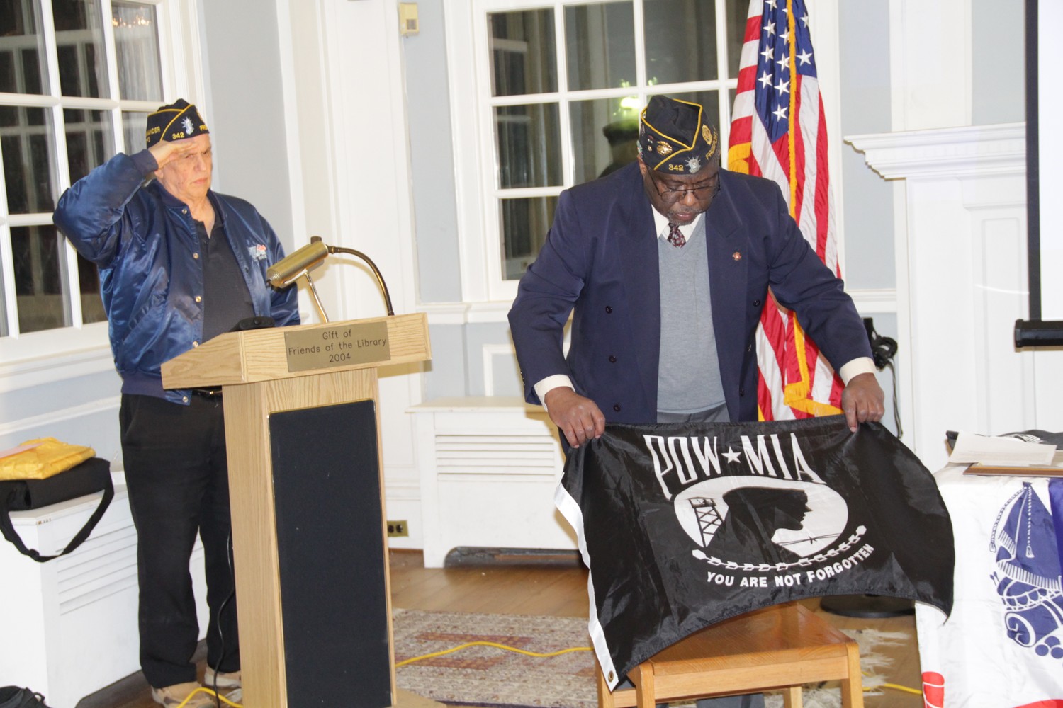 To honor prisoners of war and comrades missing in action, 1st Vice Cmdr. David Cockerel placed a POW-MIA flag on an empty chair during the Pearl Harbor Observance and Memorial Ceremony at the Freeport Memorial Library on Dec. 7.