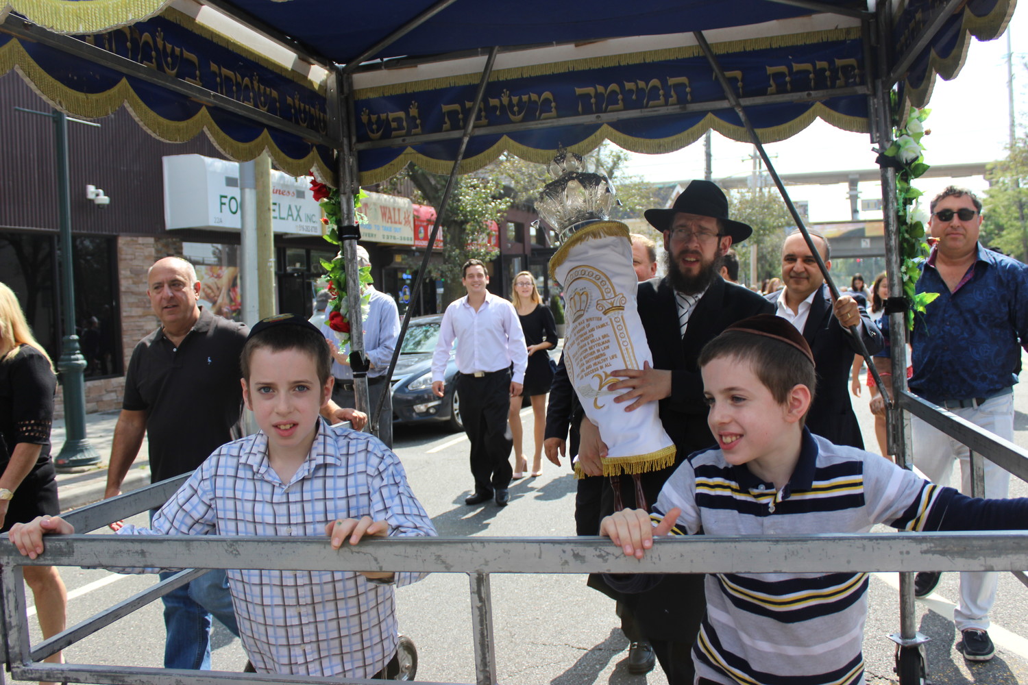 Rabbi Shimon Kramer, of the Chabad Center for Jewish Life in Merrick, marched up Merrick Avenue with his congregation’s new Torah scroll when it was unveiled this fall. His sons Binyamin and Leibel, both 10, joined him.