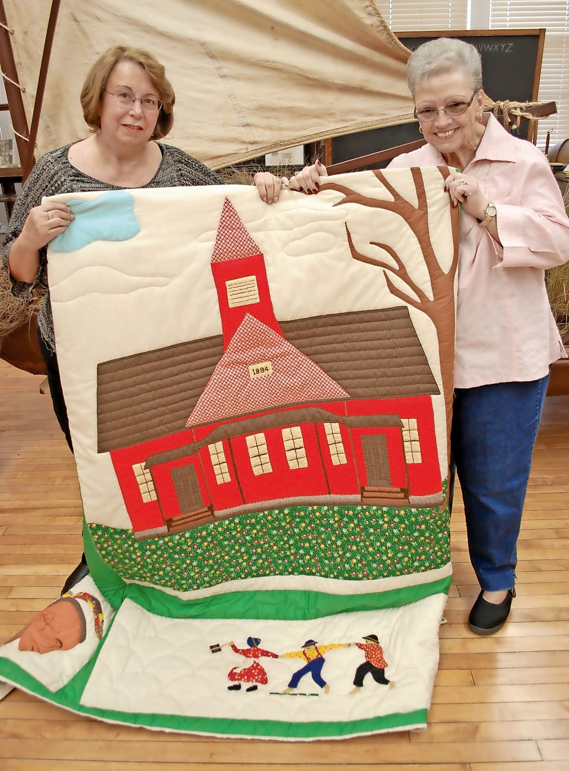 Bongiovi and past Chamber of Commerce President Carla Powell showed off a quilt made in the mid-1970s by 16 women in Seaford, depicting the former schoolhouse that now serves as the local history museum.