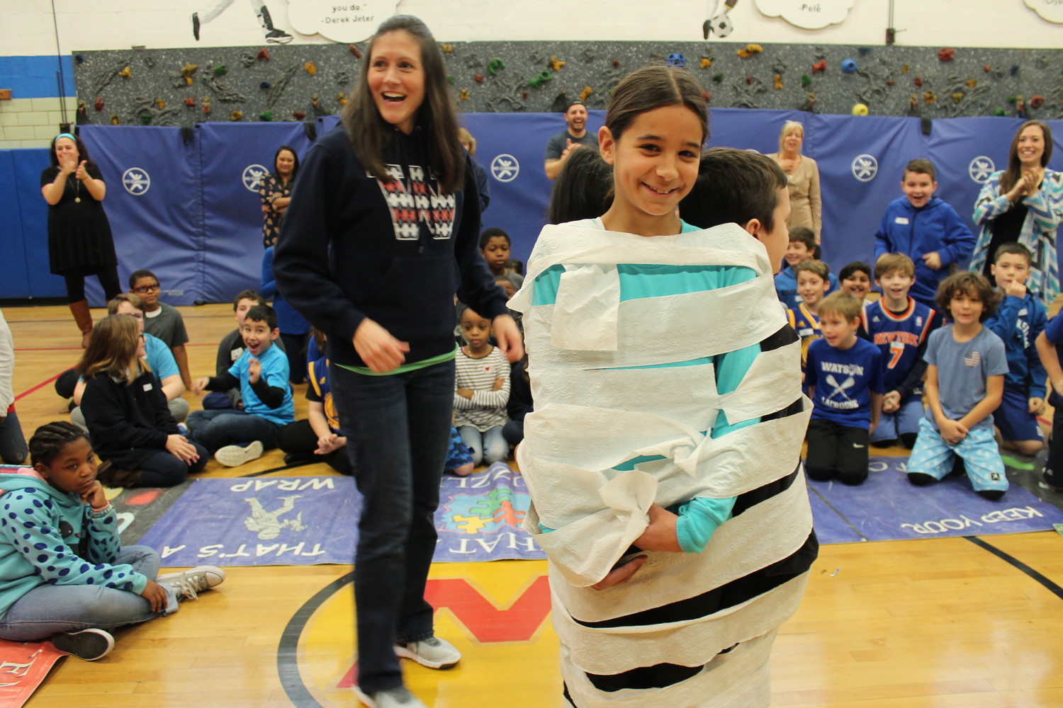 Fifth-grade teacher Andrea Grubb wrapped up Ella Santos and two of her classmates. This group won the toilet paper wrap-up competition.