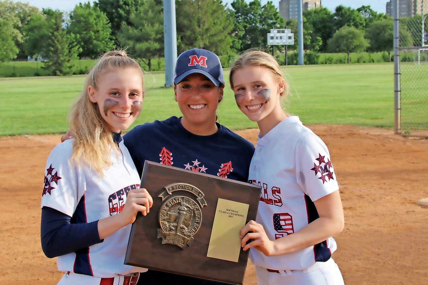 Ashley Budrewicz, left, her sister, Jessica, right, and MacArthur High School assistant softball coach Deana Tororici, center, celebrated their win in the Nassau County Softball Division A Championship series last May.