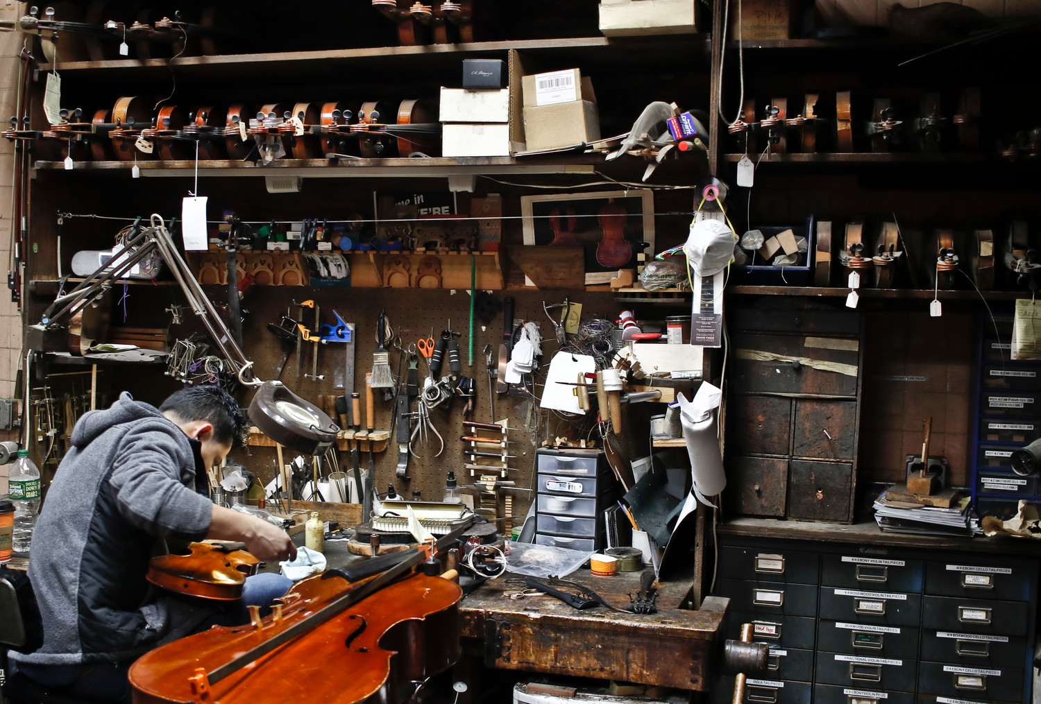 The shop is full of hundreds of tools used to restore instruments. Rigoberto Dubon worked to repair a violin.