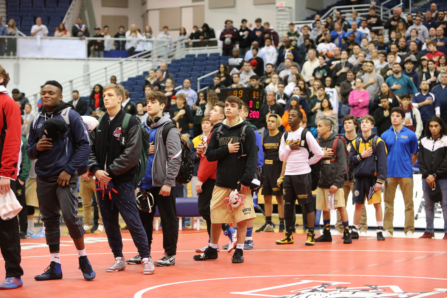 Vines, center, stood at attention for the flag with his fellow competitors. He, along with four of his teammates, would come back to the mat later in the night to win an individual county title.