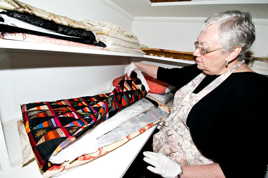 Jackie Blocklyn shows off Eleanor's many quilts. These quilts are rotated seasonally on all of the beds to avoid deterioration, which would happen if they were to remain always folded in the Linen Room.