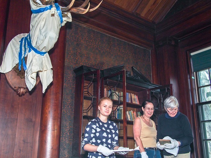 (L-R) Laura Cinturati - museum technician, Leslie Handler -volunteer, Nancy Hall - volunteer) in the North Room of Sagamore Hill. Boxes of books need to be replaced in bookcases in the specific order in which they were removed.