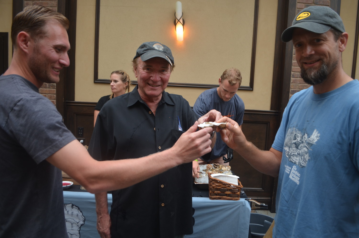 Hempstead Town Biologist Stephen Naham, left, with his father Greg Naham and Adelphi University Marine Biology Professor Aaren Freeman at the Oyster Fest kickoff launch party at JJ Coopers on Aug. 14.