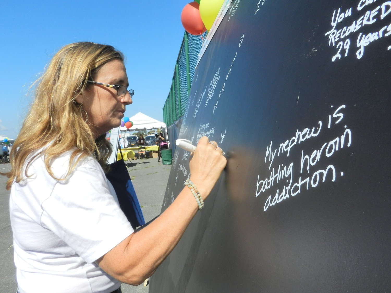 Alison Cammardella, sector coordinator of the North Shore Coalition Against Substance Abuse, signed the remembrance wall created in tribute to those affected by substance abuse.