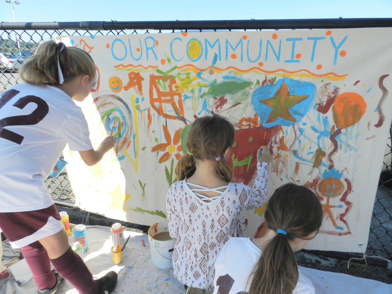 Glenwood Landing students Hailey Colbert, left, and Juliet and Abigail Monte contributed to NSCASA’s community art mural.