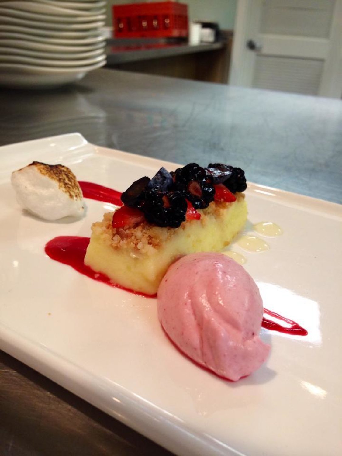 Lemon bar with shortbread crumble, raspberry mousse, toasted meringue and berries.