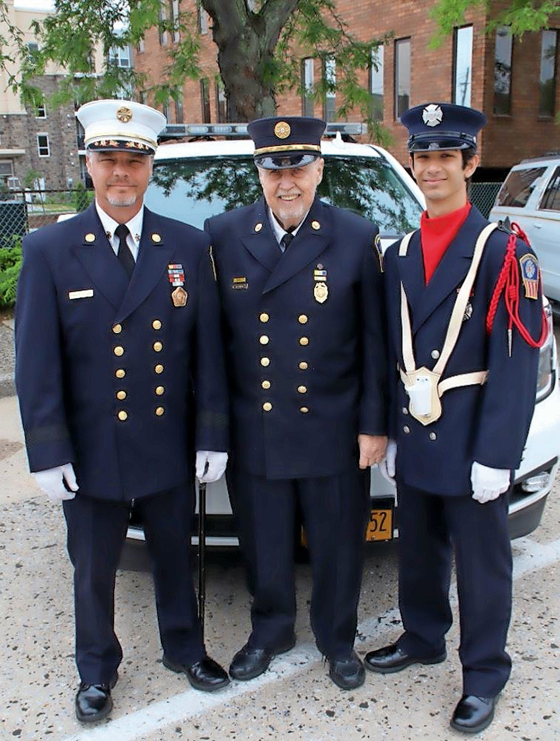 Honorary Fire Chief Thomas Cook, center, with his son, Brian, left, chief of department, and his grandson Johnny, a probationary firefighter, at Rockville Centre's Memorial Day Parade in May.