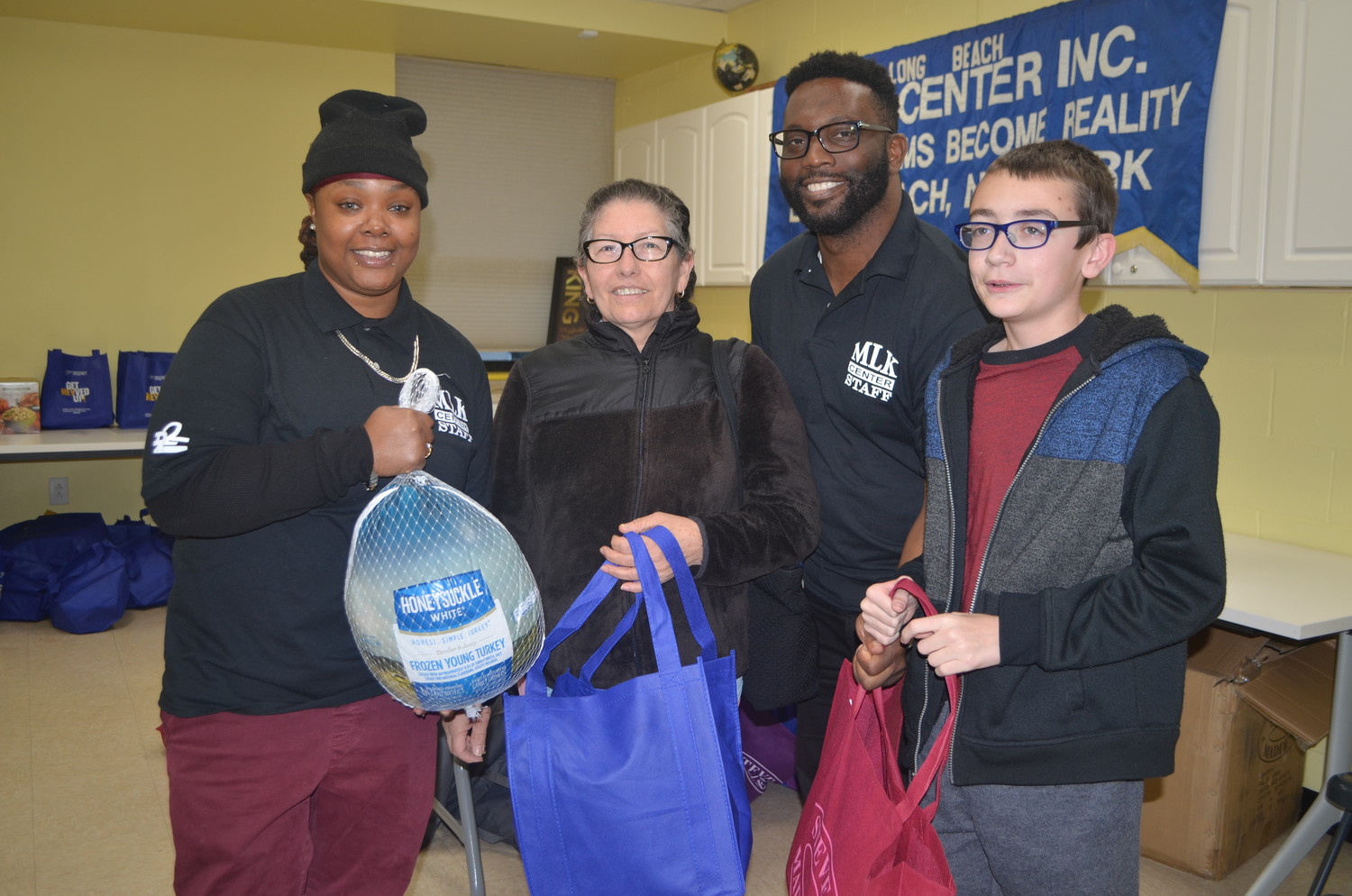 Nyasia Hurd, left, Hodge and Jacob Hurney, far right, handed a turkey and dinner trimmings to Norma Castro.