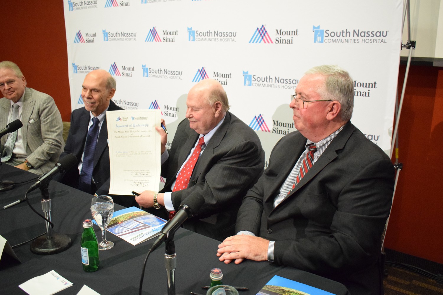 Representatives of South Nassau Communities Hospital and the Mount Sinai Health System announced their partnership Tuesday. Joseph Fennessy, the chairman of SNCH’s board of directors, held the ceremonial agreement that was signed. WIth him, from left, were Mount Sinai President Dr. Arthur Klein, Mount Sinai CEO Dr. Kenneth Davis and South Nassau President and CEO Richard Murphy.