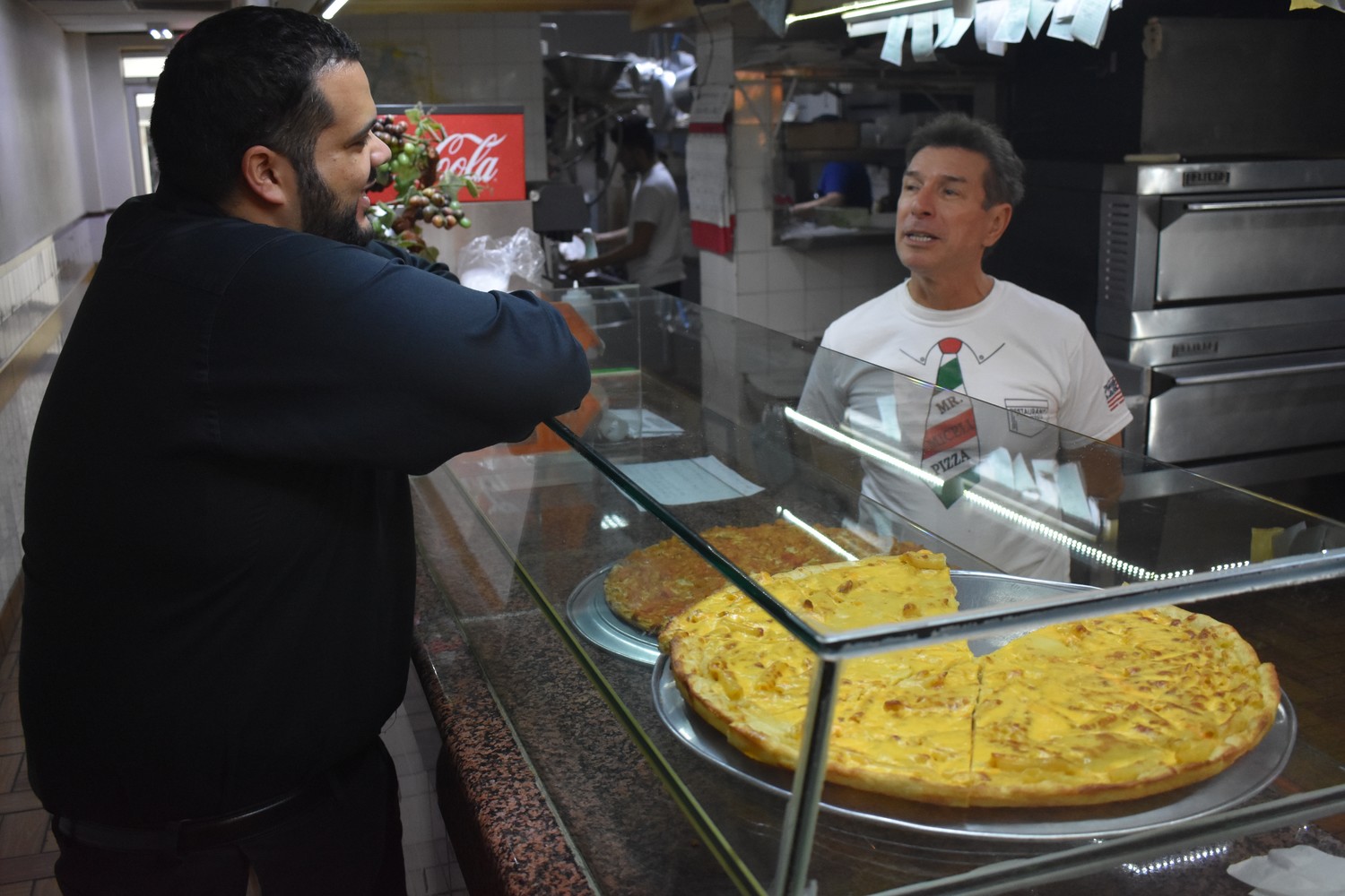 Luca Miceli, owner of Mr. Miceli Pizza, above, chatted with customer Joel Fernandez a day before Miceli closed his shop. “It was a pleasure,” Fernandez told him with a handshake before leaving.