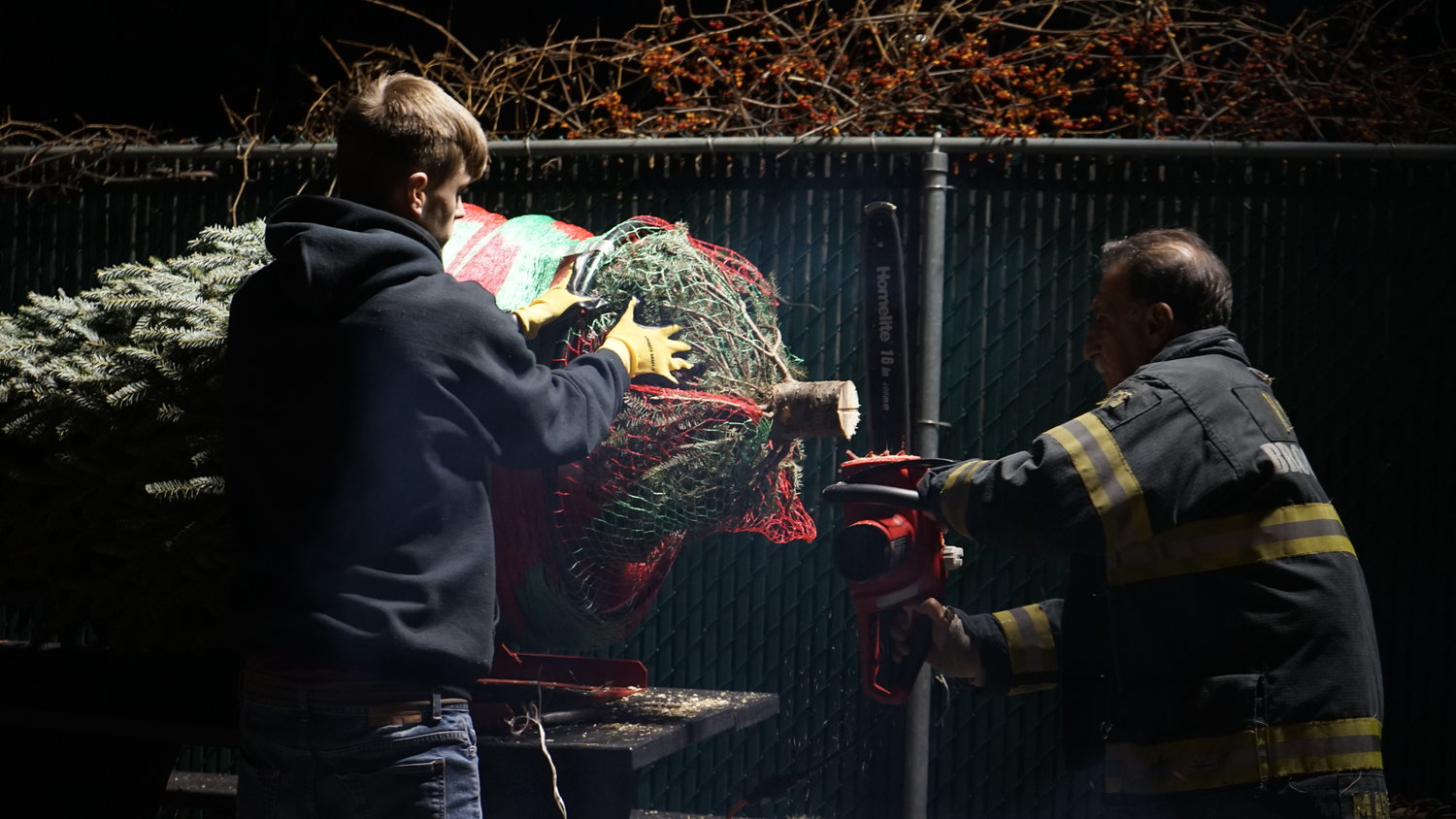 Firefighters Sean McBride, left, and Ronny Mastrangelo readied a tree for sale.