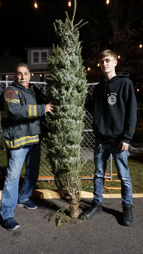 Mastrangelo and McBride with one of the larger trees they have available. The trees run from three to eight feet in height.