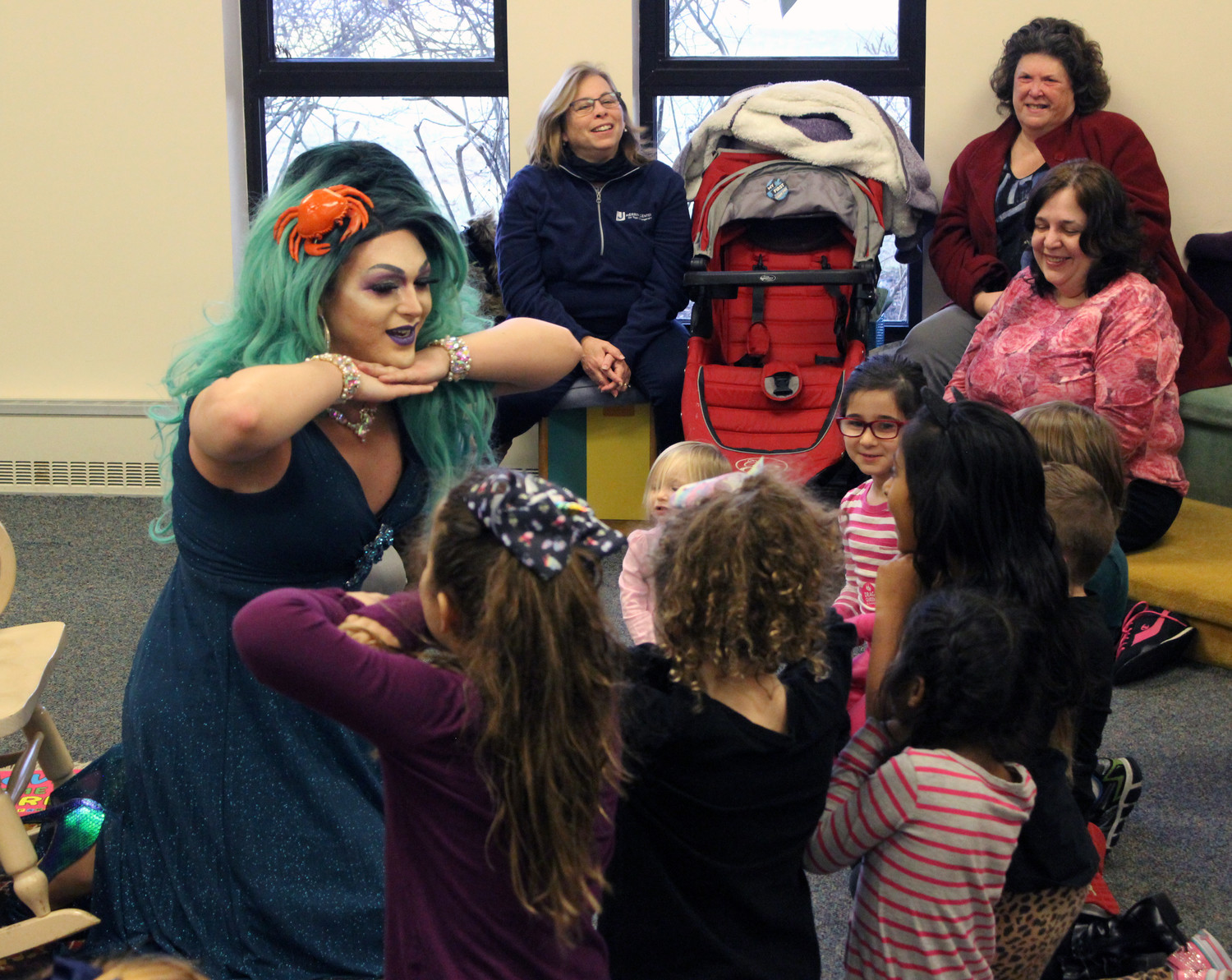 Manhattan-based drag queen Bella Noche made like a mermaid with children who attended the Drag Queen Story Hour at the East Meadow Public Library last Saturday.