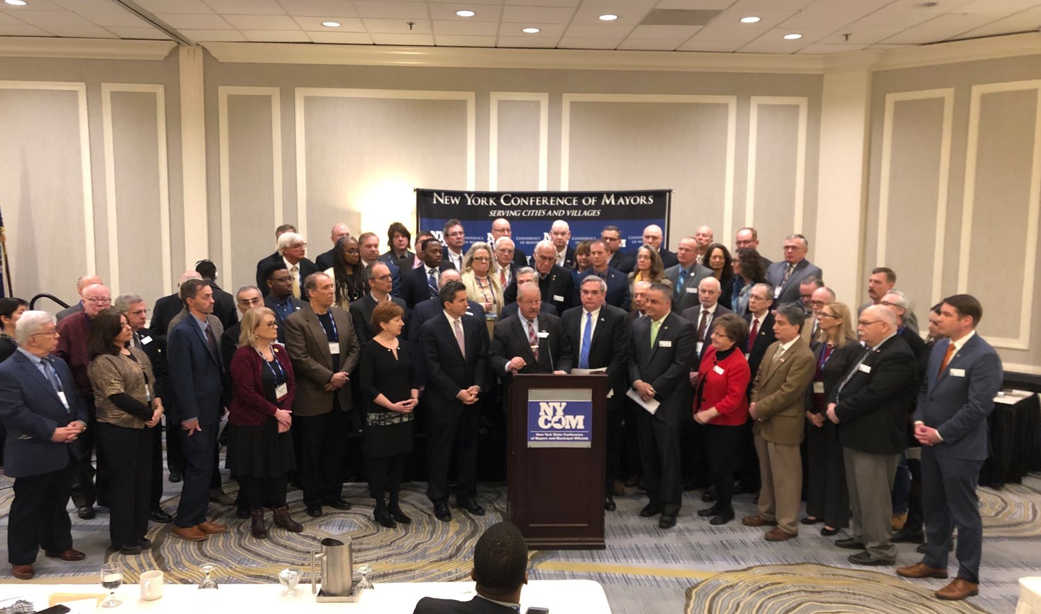 Mayor Robert Kennedy, at the lectern, was joined in Albany on Monday by 540 mayors from across New York demanding that Governor Cuomo restore Aid and Incentives for Municipalities funding.