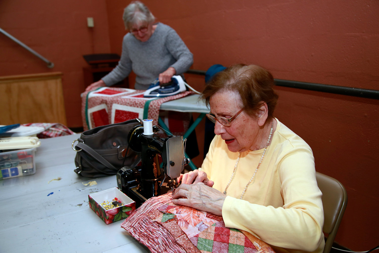 Ellen Paplia sewed quilts while Paula Mazzola ironed them.