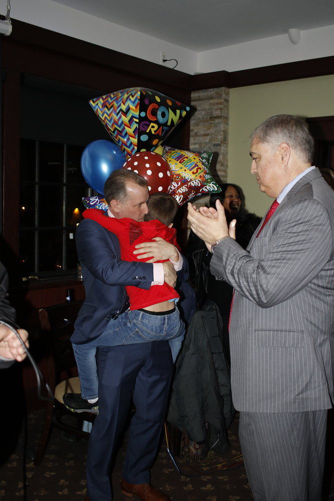 New Board of trustees member Chris Squeri’s son, Hudson, hugged his father shortly after the election results, while Jorge Martinez looked on.