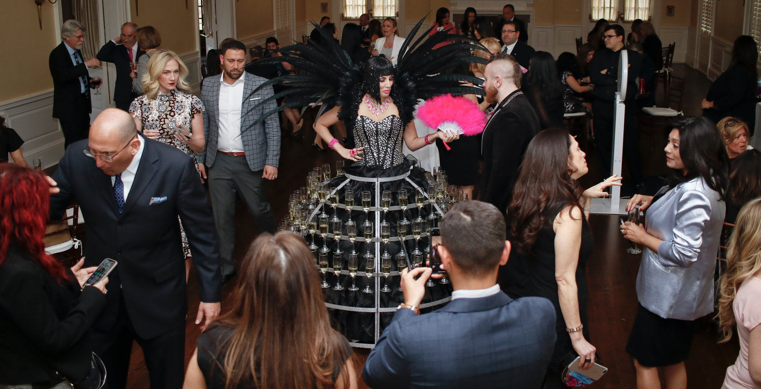 A performer wore a dress that held 102 champagne glasses during the VIP cocktail hour.