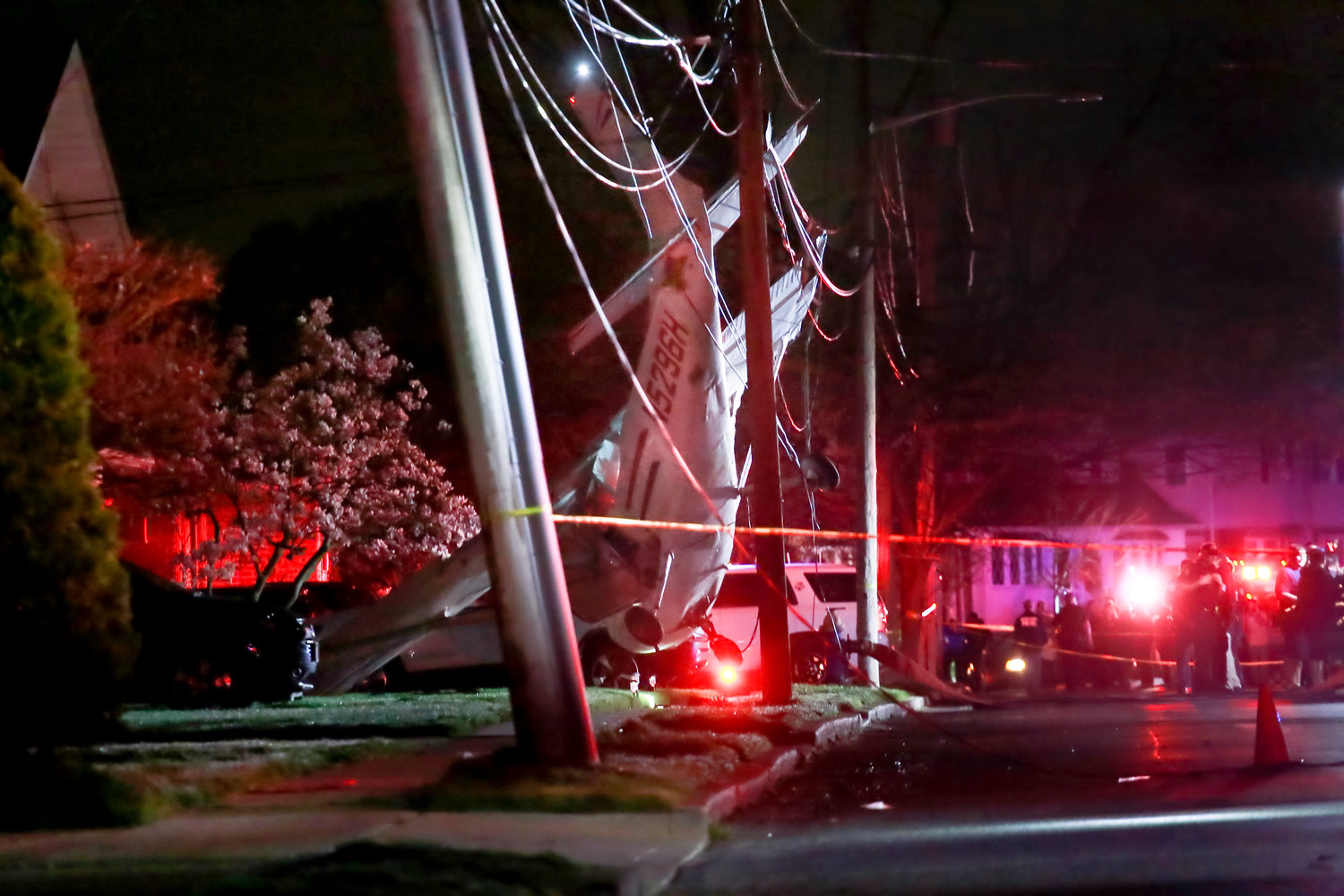 A single-engine prop plane was suspended a foot off the ground by power lines it crashed into in front of a Clarendon Drive home on Sunday. The pilot and passengers were unharmed.
