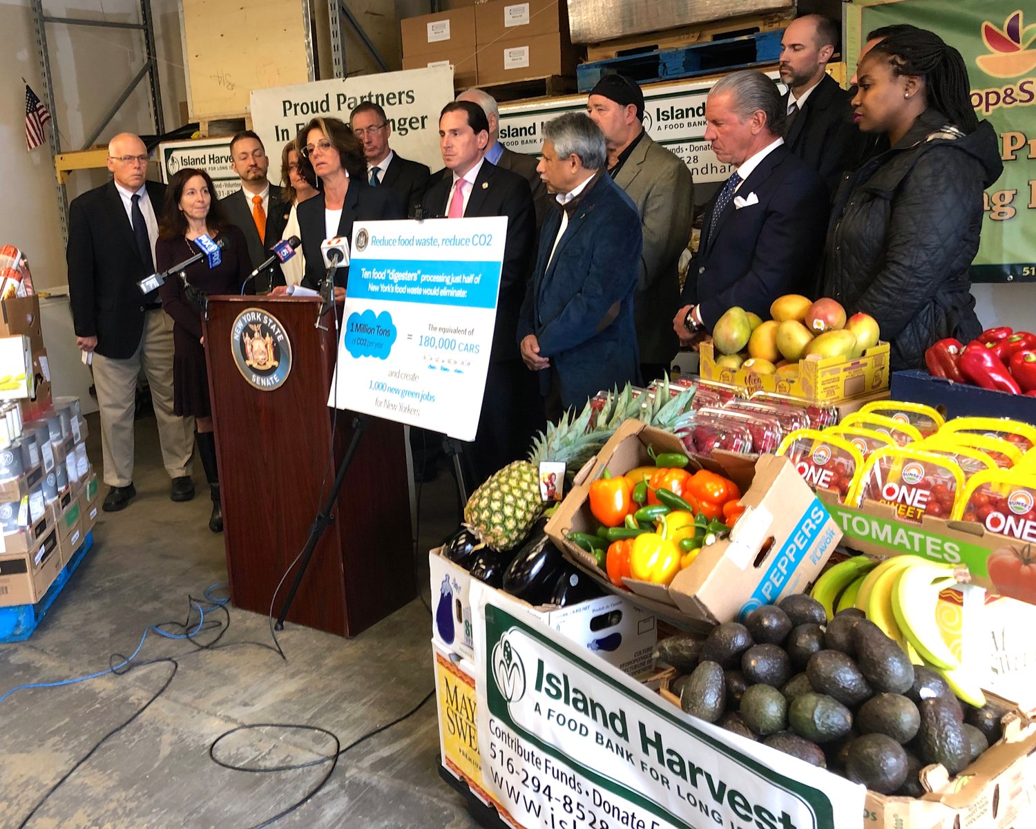 Island Harvest President Randi Shubin Dresner, at lectern, with State Sen. Todd Kaminsky to her right, was among the officials last Thursday to announce passage of a measure to reduce food in the waste stream by requiring large retailers to send unsellable but edible food to recovery organizations like Island Harvest.