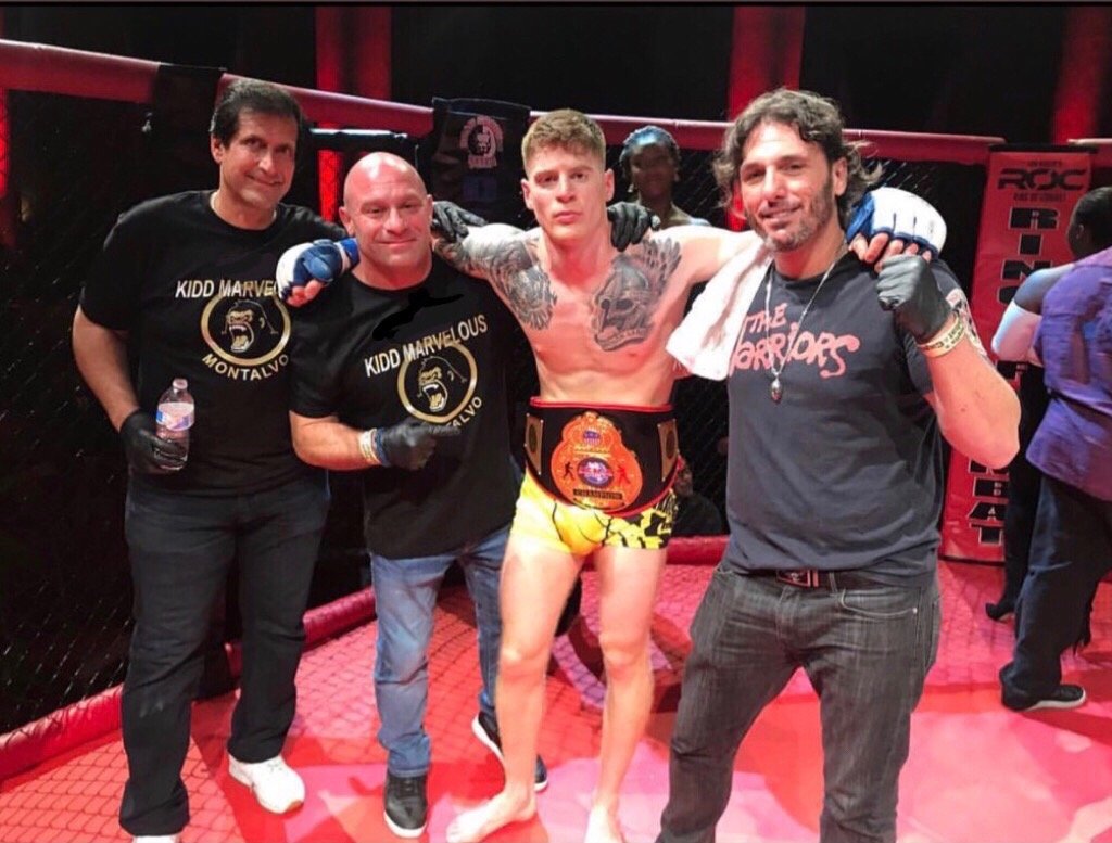 Campbell, wearing the International Sport Karate Association New York MMA championship belt with, from left, coaches Ray Longo, Matt Serra and Eric Hyer, who have helped prepare him for the fight.