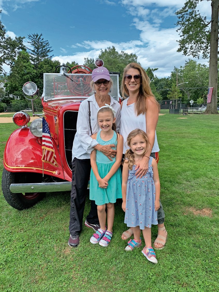 Janet Swinburne, top left, joined Caitlin Swinburne and her daughters, Hope, 8, bottom left, and Hadley, 4, in front of an early-20th-century fire vehicle.