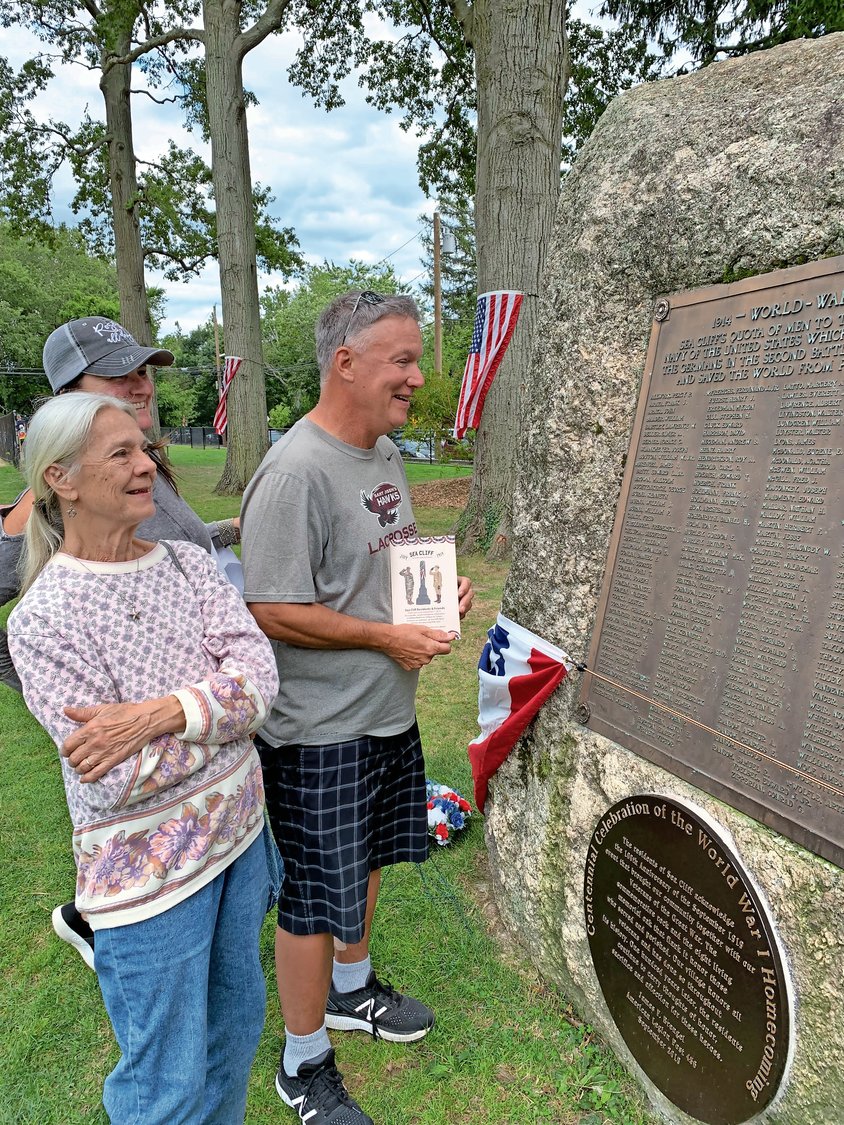 Lia Buffa, left, Joni Sturge and Mike Cain discussed the stories of the 177 soldiers on the memorial rock’s plaque.