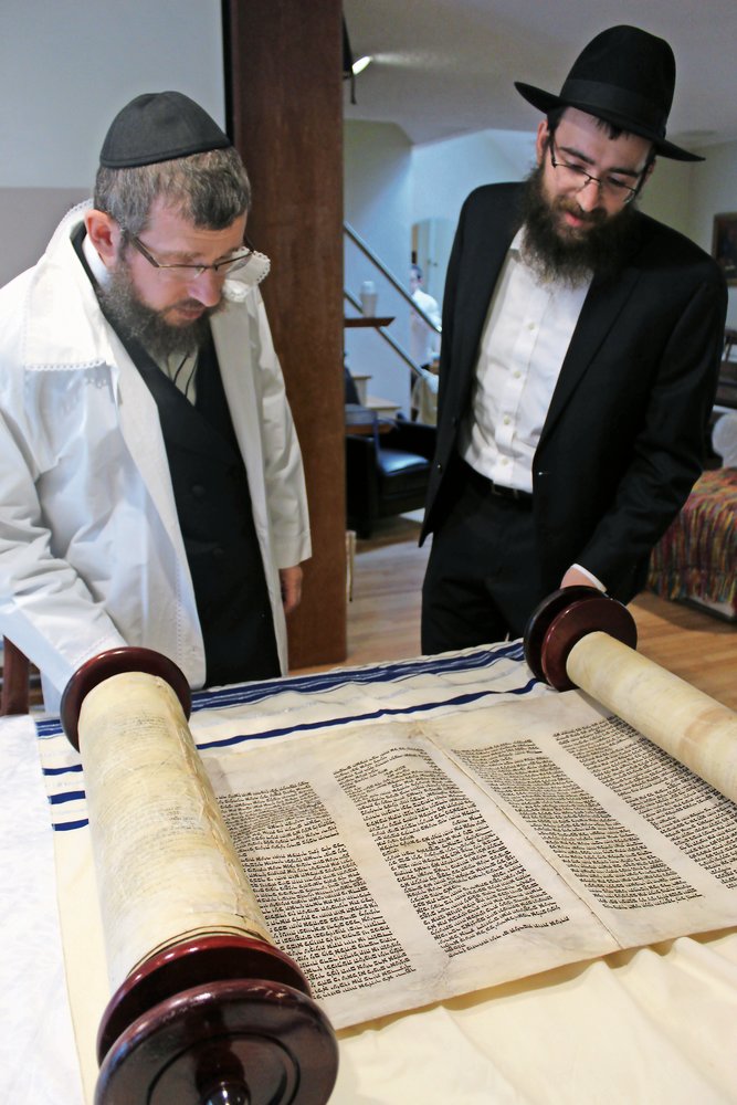 Rabbi Shimon Kramer and Cantor Nissen Pewzner admired the Kristallnacht Torah.