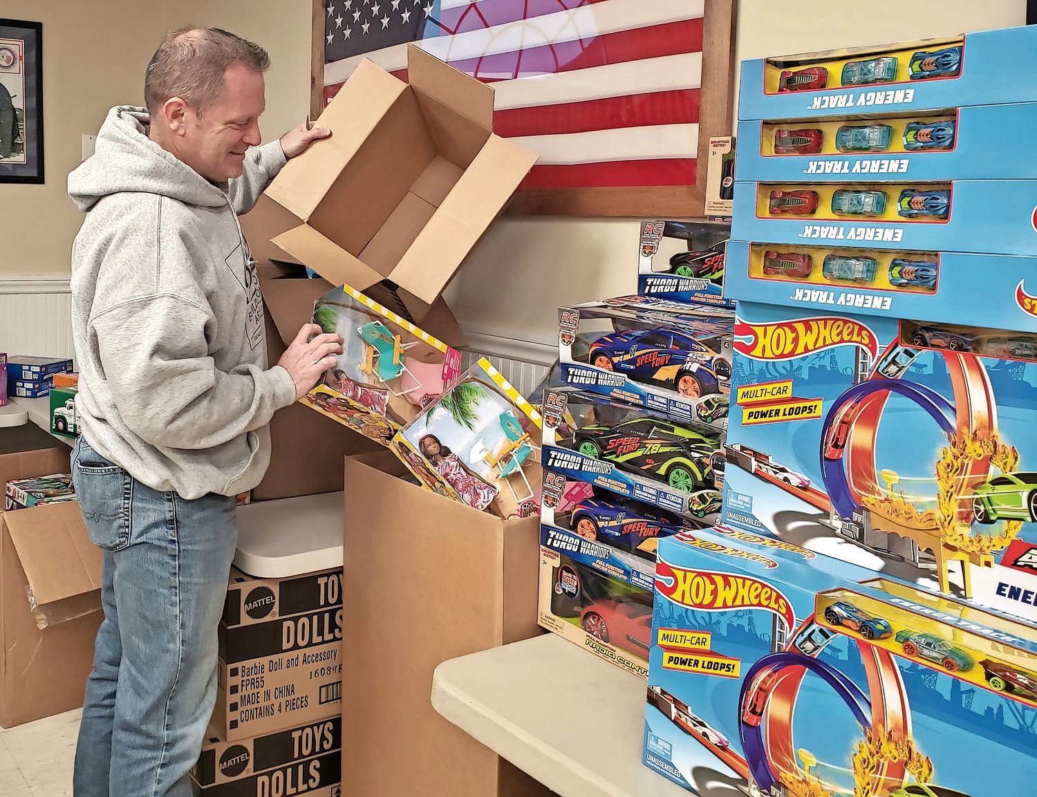 On Dec. 18 Franzone spent the day at the Freeport PBA, left, unboxing hundreds of toys for the giveaway.