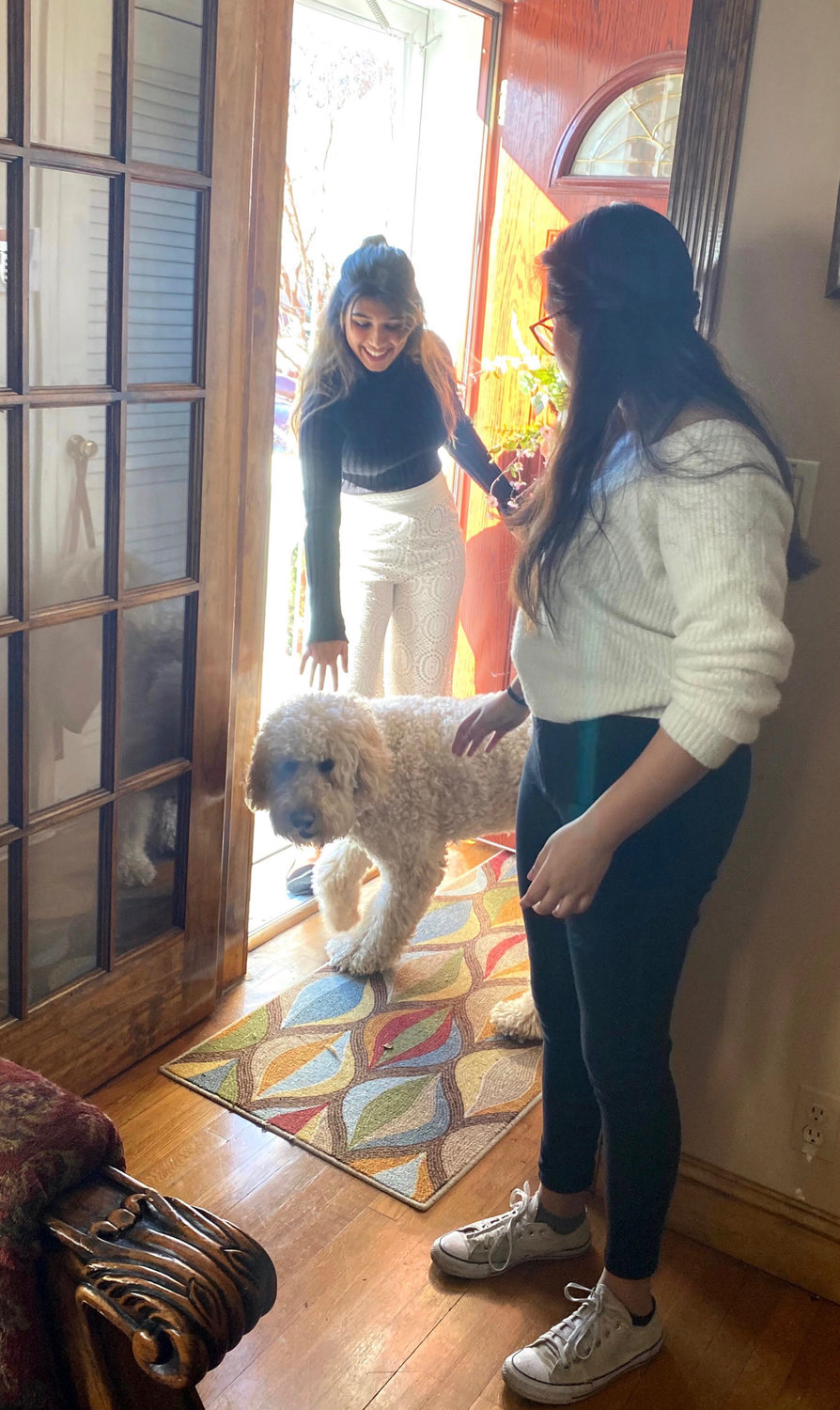 Recent South High School graduate Abigail Arjune, left, with her sister, Sarah, and their goldendoodle, Orion. The sisters have been walking together more as they develop new routines while staying at home.