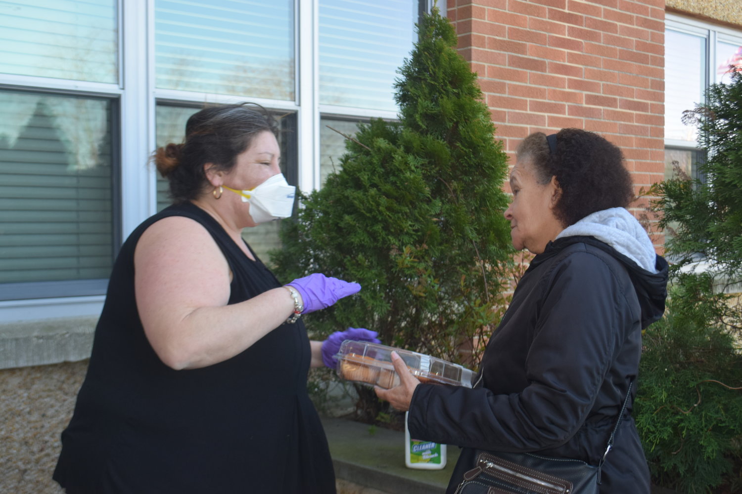 Inwood resident Sasha Young, left, distributed food to other Five Towns residents at the Community Center in Lawrence on March 27.