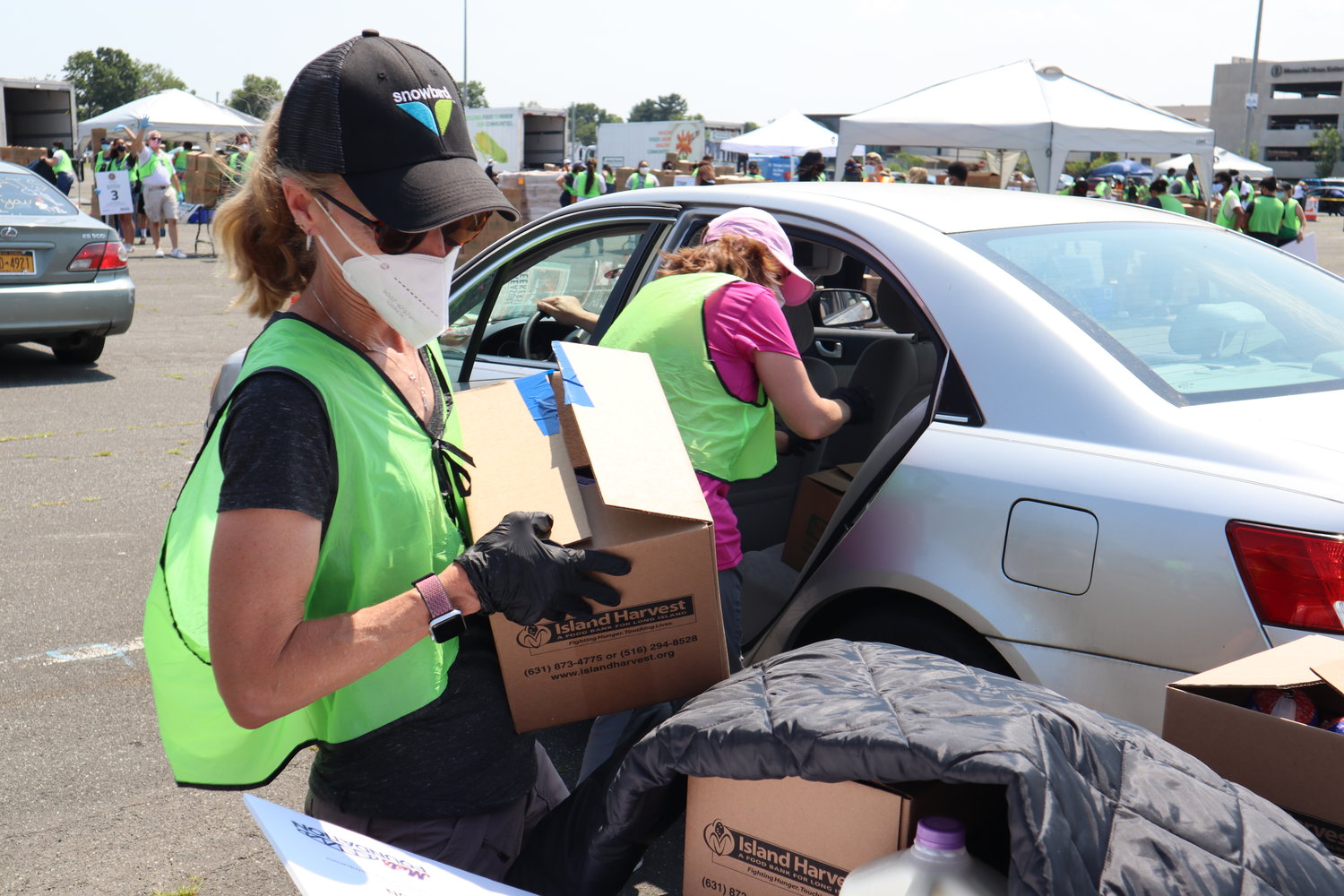 Volunteers packed boxes filled with goods into a steady stream of vehicles.
