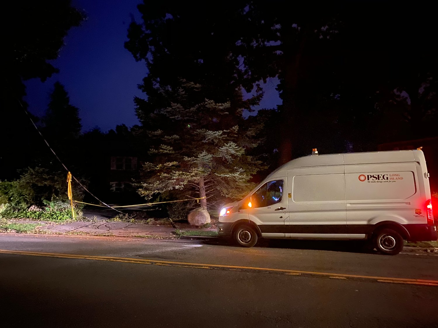 A PSEG Long Island vehicle stationed at a downed electrical wire on Dosoris Lane Thursday night.