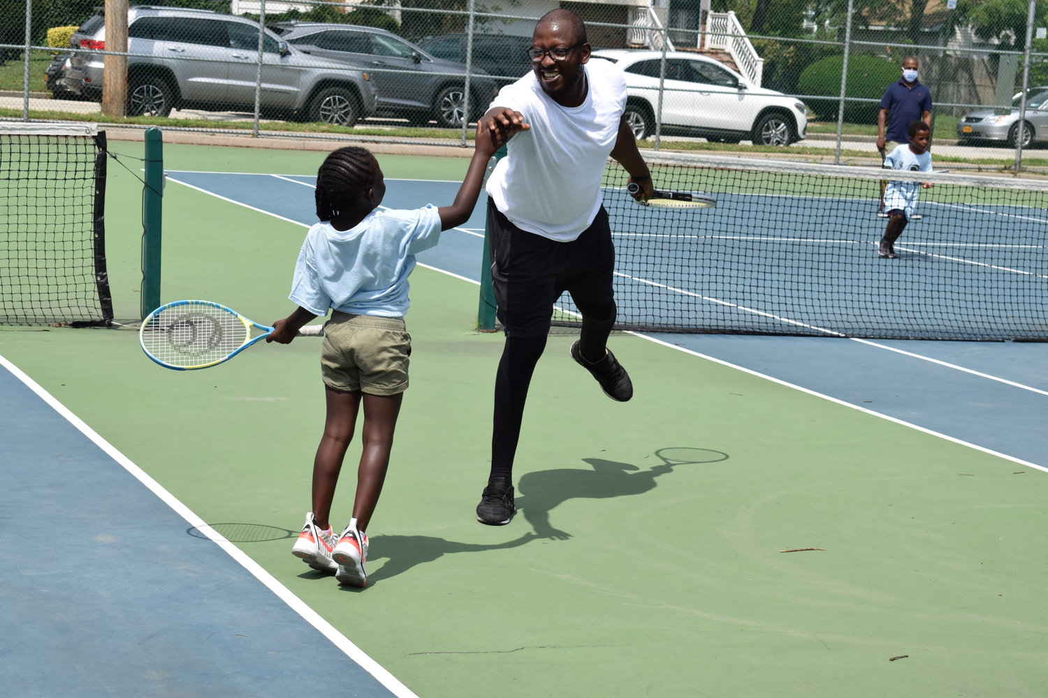 Obeng Dwamena high-fived his daughter, Aneesa Dwamena, 6, during a friendly game in the Learning Institute of Tennis, Life Skills and Sportsmanship’s summer program.