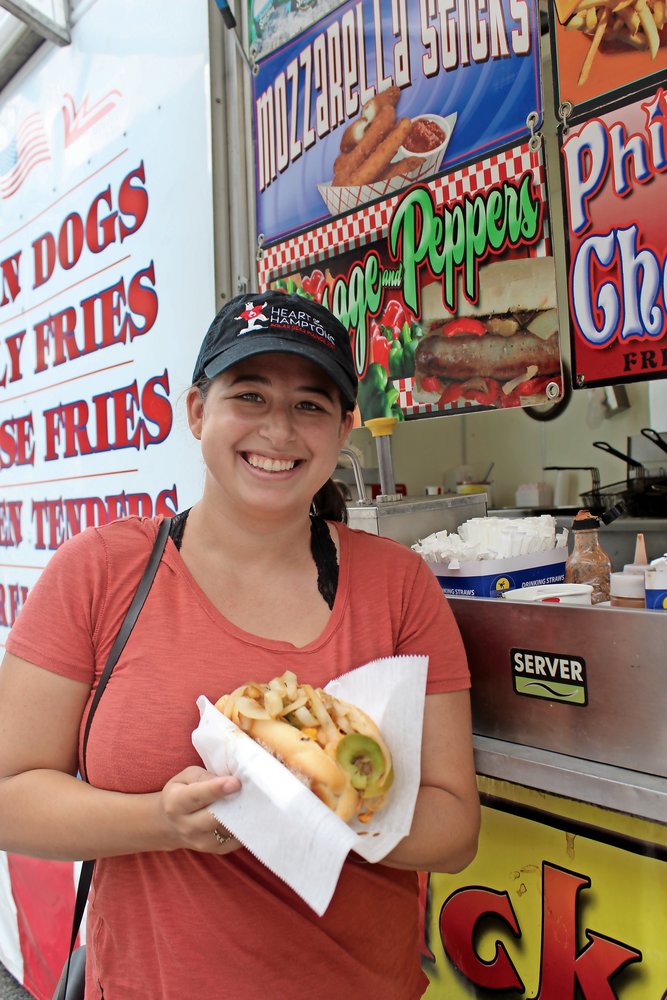 Festival-goers come for food, rides and to shop at hundreds of booths operated by local businesses. In 2019, Amanda Bernocco, of Merrick, took advantage of the food trucks at the festival, ordering a Philly cheese steak.