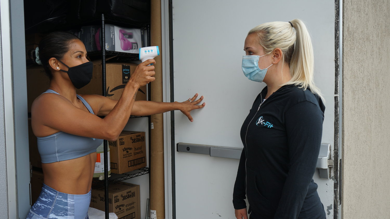 Melo, left, will check her clients’ temperatures before they enter her studio as she restarts indoor classes.