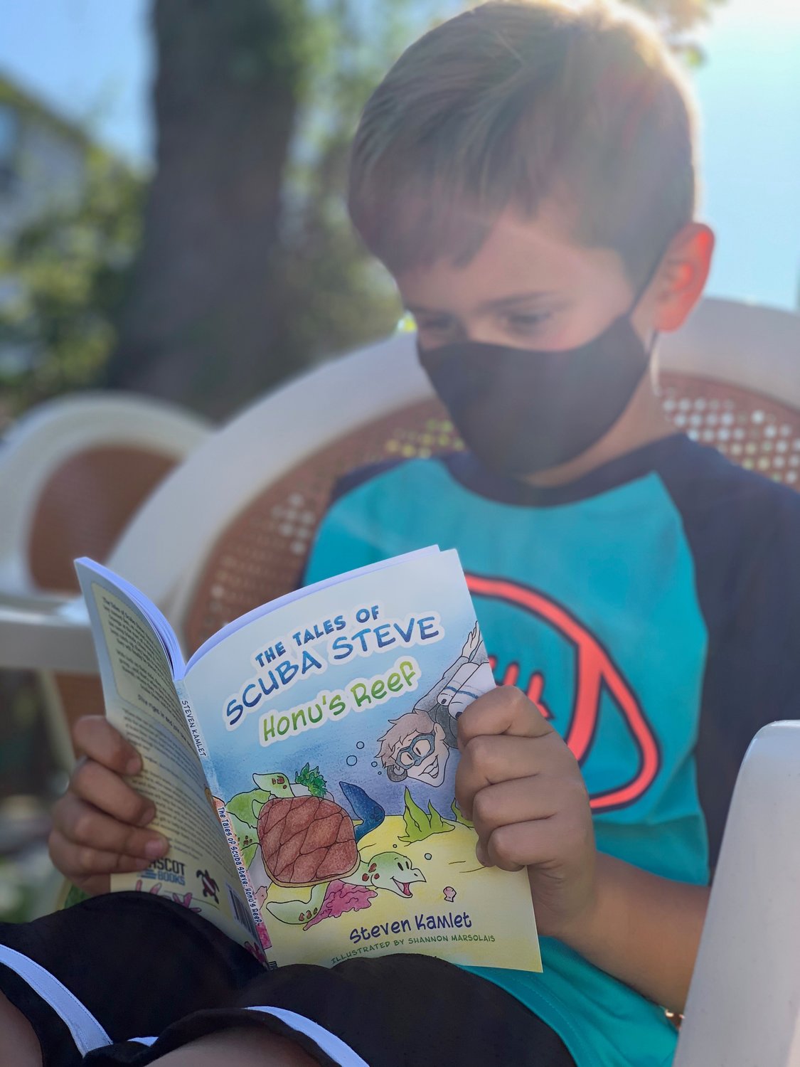 Hunter Rogoff, of Merrick, reads “Honu’s Reef,” the first book in “The Tales of Scuba Steve” series. In the book, a group of summer campers go on an undersea adventure to reconstruct Hawaii’s coral reefs.