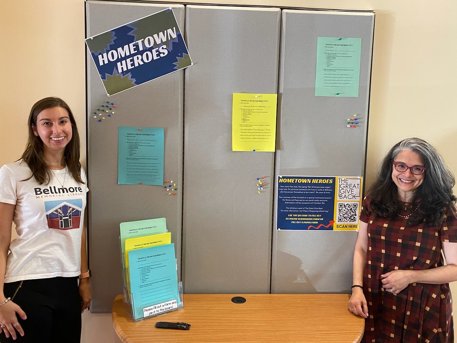 By the end of October, the Hometown Heroes board in the Bellmore Memorial Library will be filled with stories of individuals who serve the community. Librarians Pam Pagones, near right, and Martha DiVittorio helped organize the initiative as part of the Great Give Back.
