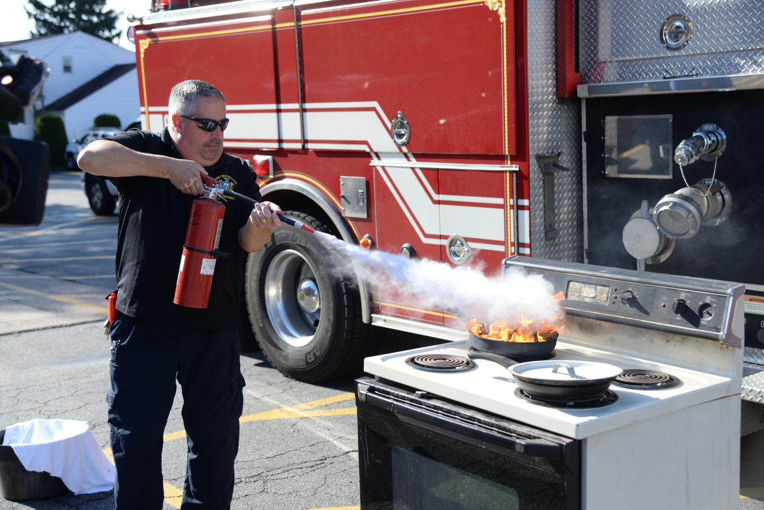 EMFD Fire Inspector and Ex-Chief James Kane demonstrates how to put out a stove fire using a fire extinguisher.