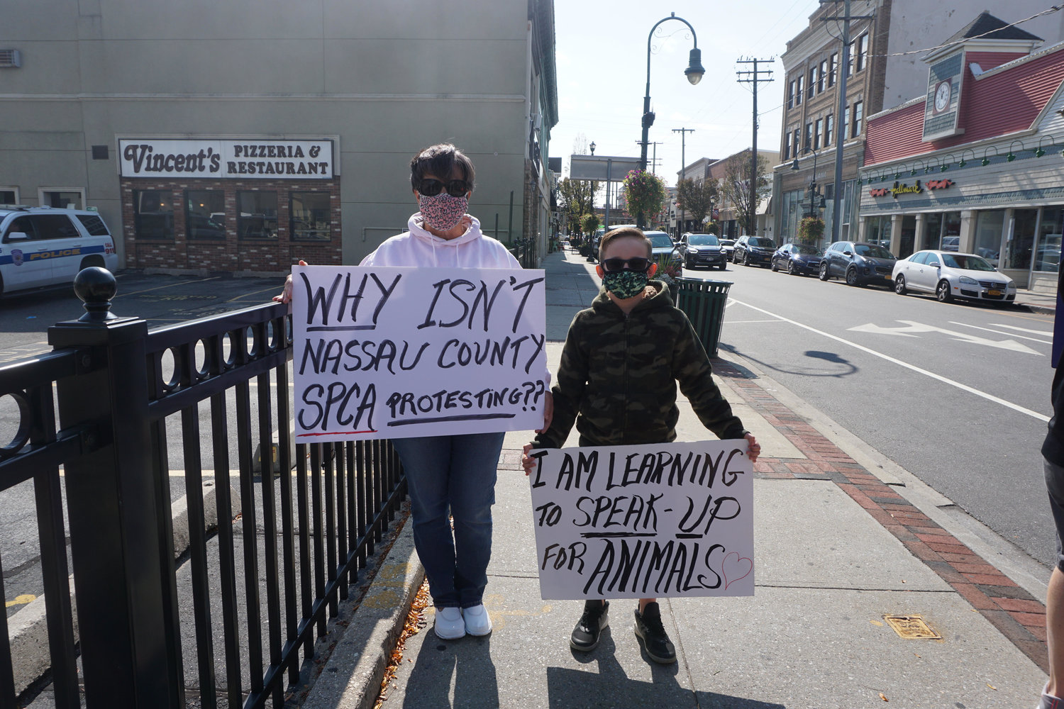Diane Madden, left, protested outside Shake A Paw with Connor Brugge.