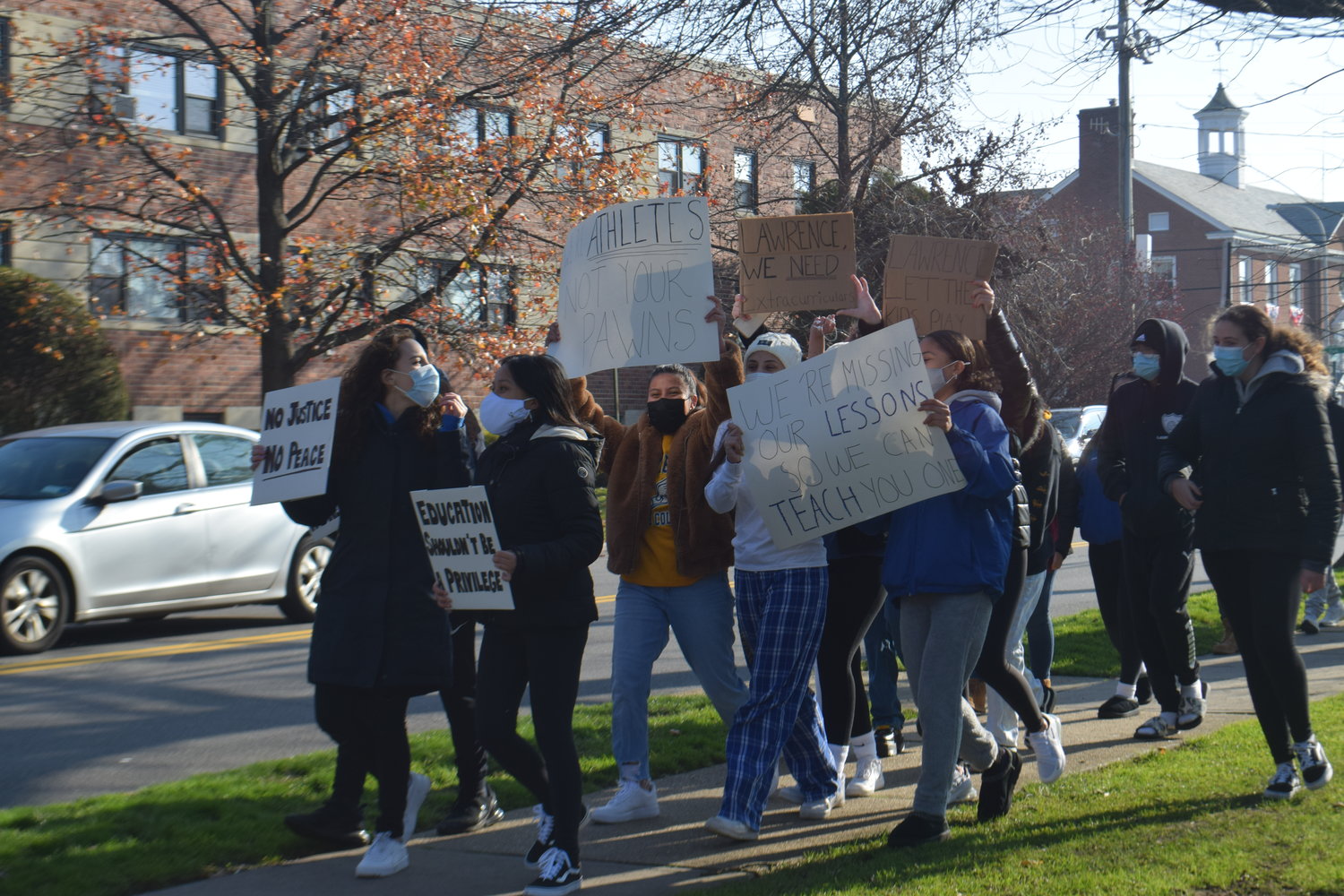Lawrence High School students protested the loss of two sports seasons and not having virtual clubs as they marched along Cedarhurst Avenue in Cedarhurst on Dec. 11.