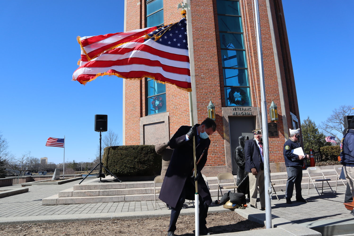 U.S. Rep. Tom Suozzi helped stand the American Flag in the turbulent wind.