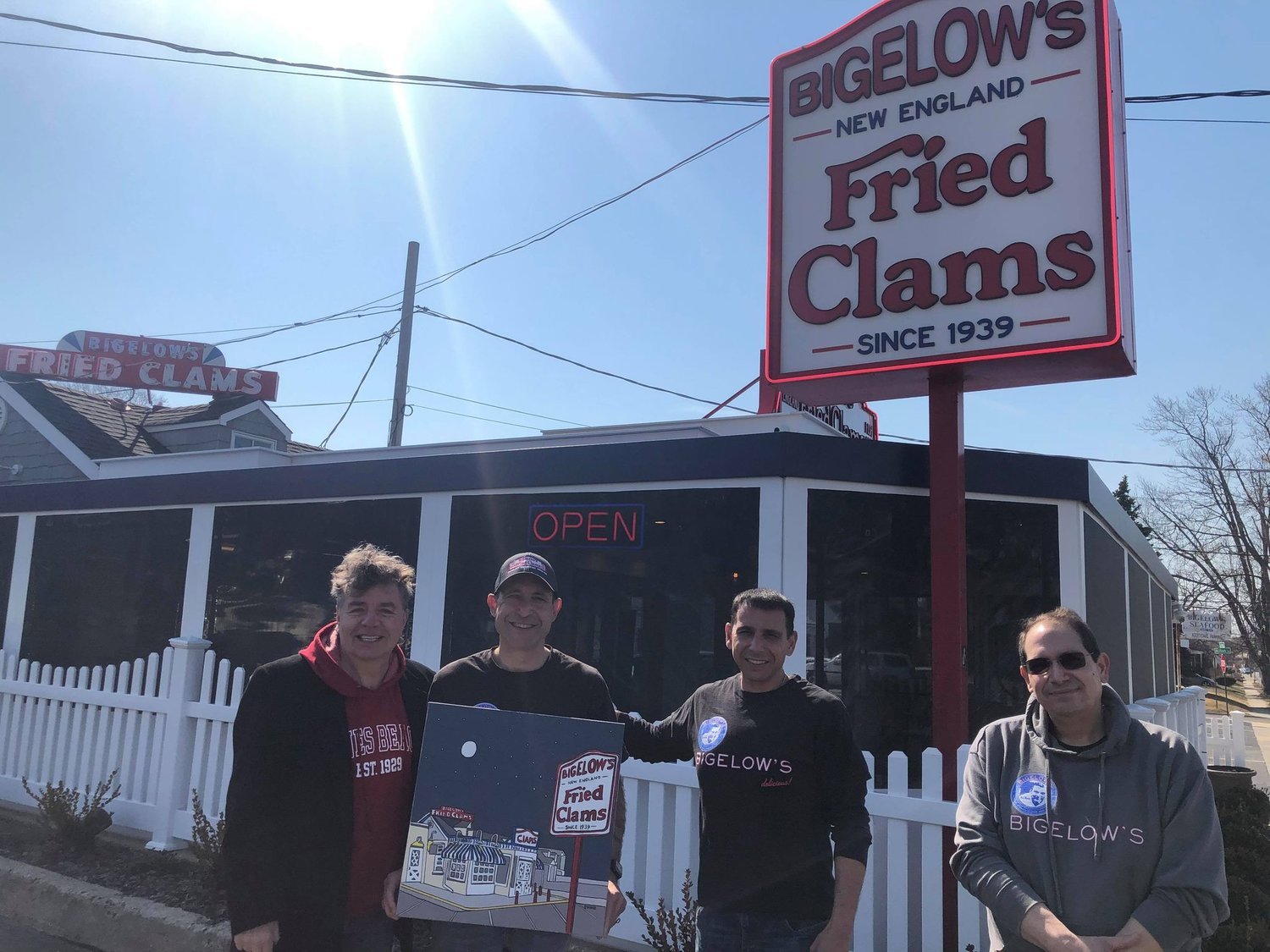 Valley Stream artist Mike Stanko, left with Bigelow’s New England Fried Clams owners and brothers Anthony, Chris and William Andreoles with the painting of their restaurant Stako gifted to them last week.
