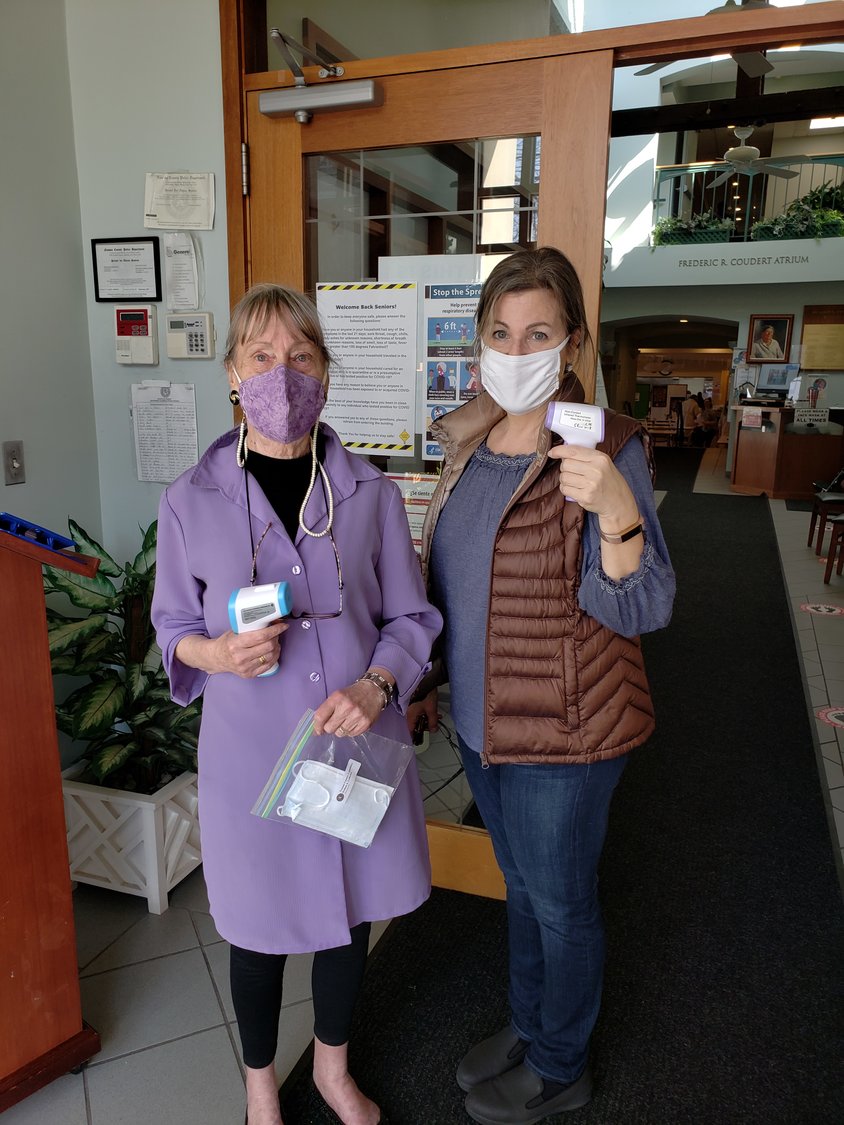 Volunteers Diane Aerne, left, and Susan Tucker were there to greet seniors and take their temperatures before they got the shots.