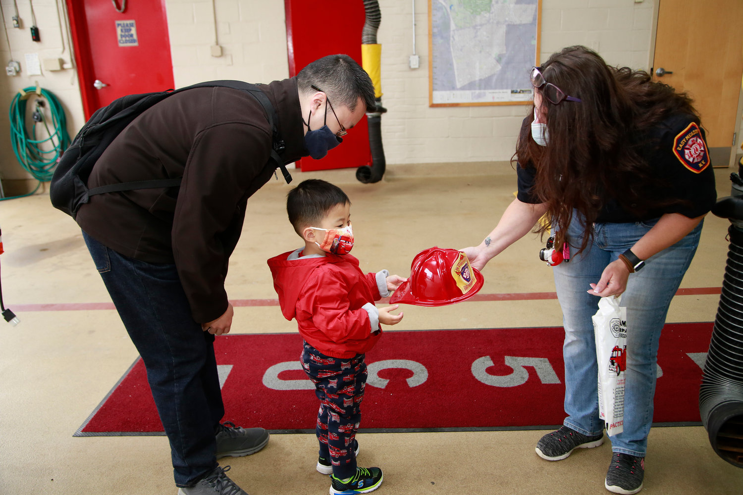 Donald Lim didn’t have to coax Theodore, 3, to accept a firefighter’s hat from Rescue Co. 5 Capt. Robin Fitzpatrick at RecruitNY last Sunday.
