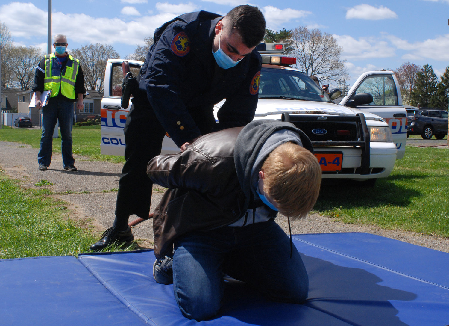 A recruit practiced placing handcuffs on a suspect, who was played by an actual police officer for this exercise.