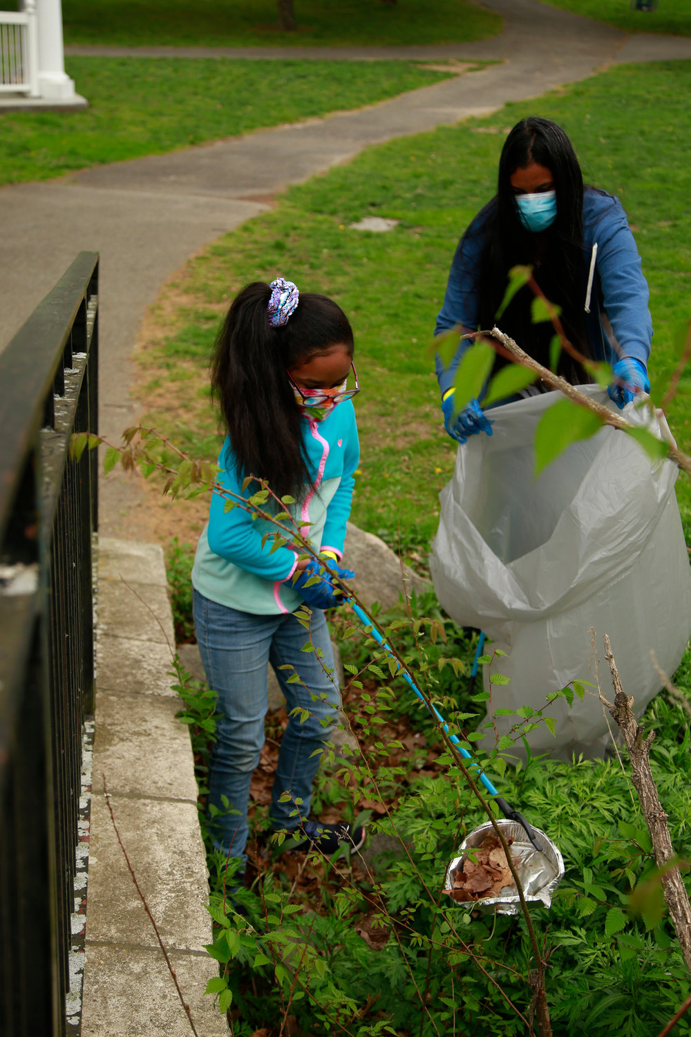 Isabela Garcia, left, 8, and her mother, Miriam, also provided helping hands during the community cleanup.